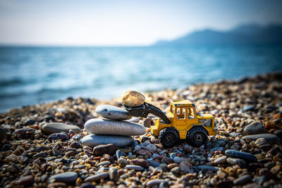 Surface level of pebbles on beach against sky