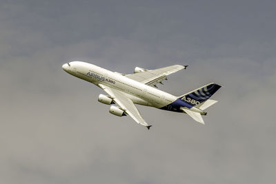 Low angle view of airplane flying against sky