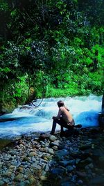 Woman sitting on rock in forest