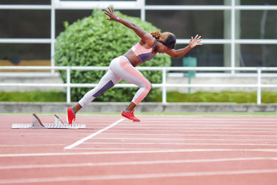 Determinant female athlete running on runner track