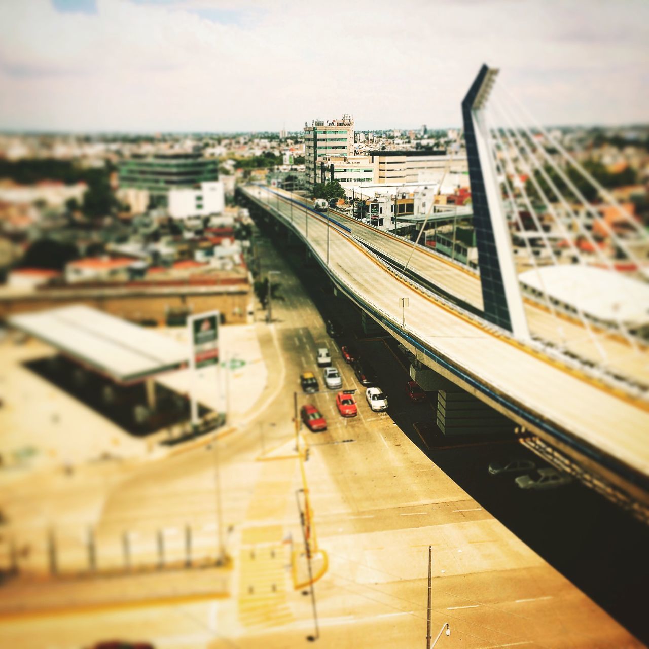 transportation, mode of transport, architecture, high angle view, built structure, land vehicle, railroad track, city, public transportation, building exterior, car, rail transportation, sky, travel, incidental people, train - vehicle, on the move, street, road, railroad station platform