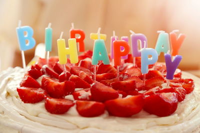 Close-up of candles and strawberries on birthday cake
