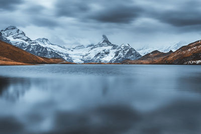 Scenic view of lake and snowcapped mountains against sky