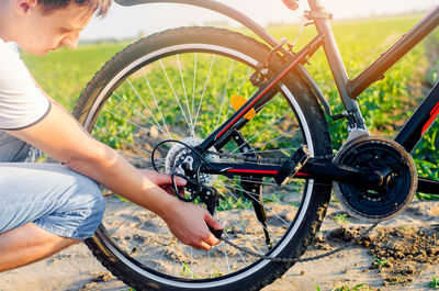 The guy repairs the bicycle. chain repair. cyclist. unratitude on the road, travel, close-up.