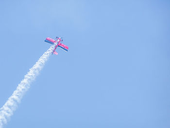 Low angle view of airplane in clear blue sky