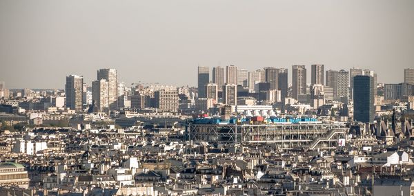 Aerial view of buildings in city against clear sky