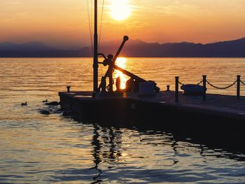 Silhouette boat in sea against sky during sunset