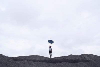 Full length of young woman jumping in sky