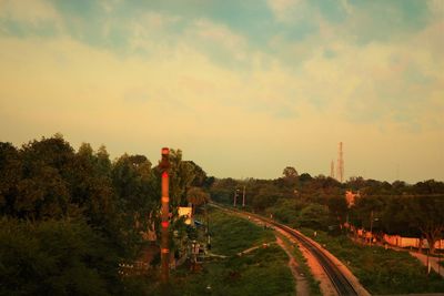 Panoramic view of road amidst field against sky at sunset