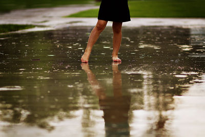 Low section of woman standing on wet water