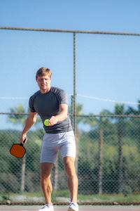 Full length of young man playing tennis