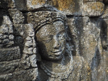 Close-up of statue against stone wall