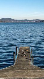 Pier over lake against blue sky