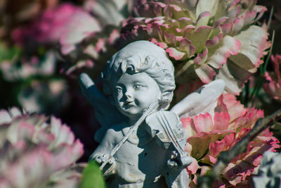 Close-up of buddha statue amidst flowering plants