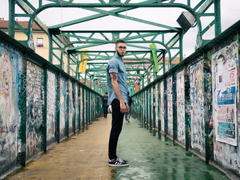 Full length portrait of man standing on cobblestone