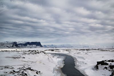 Scenic view of snow covered land against sky