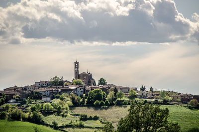 Buildings in city against cloudy sky