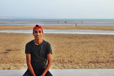 Portrait of smiling young man on sitting on beach