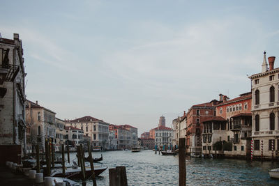 Canal in city against sky