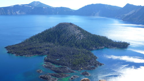 High angle view of sea and mountains against sky