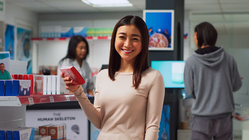 Portrait of smiling young woman standing at airport