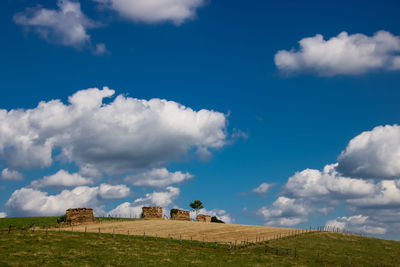 View of old wall on landscape against cloudy sky