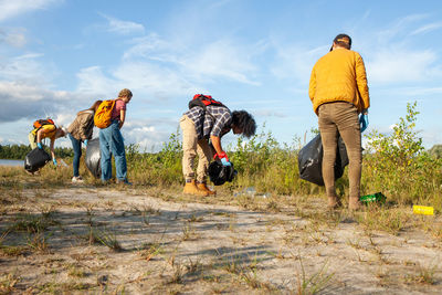 Rear view of people walking on field