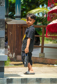 Side view of boy standing on railing