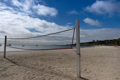 Volleyball net at beach against sky