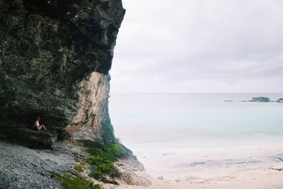 Scenic view of sea by cliff against sky