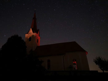 Low angle view of illuminated building against sky at night