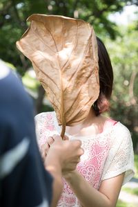 Close-up of woman holding autumn leaf