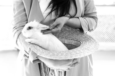 Woman holding rabbit in hat