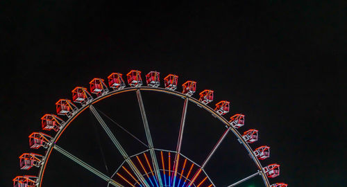 Low angle view of illuminated ferris wheel against sky at night