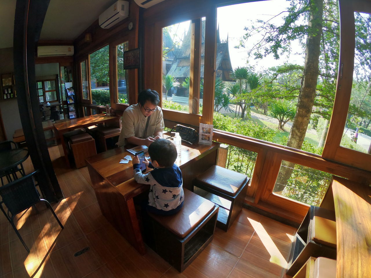 MAN SITTING ON TABLE BY WINDOW