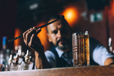 Midsection of man holding beer glass
