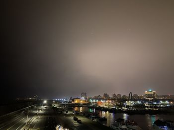 High angle view of illuminated cityscape against sky at night