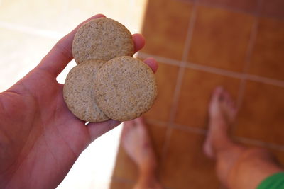 Close-up of person holding hand on tiled floor