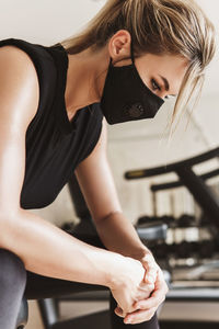 Woman wearing mask exercising at gym