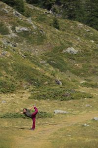 Woman exercising on grassy field