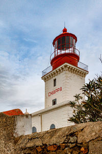 Lighthouse by sea against sky