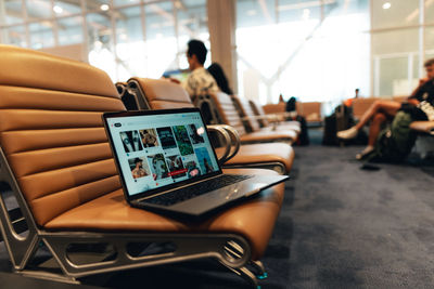 Rear view of woman using laptop at table