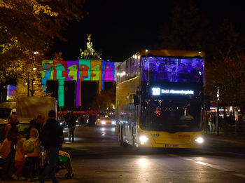 People on illuminated city street at night