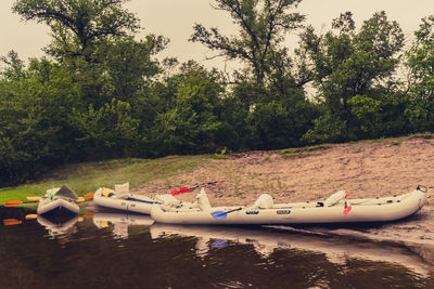 Boats moored on lake against sky