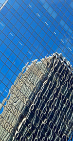 Low angle view of glass building against sky