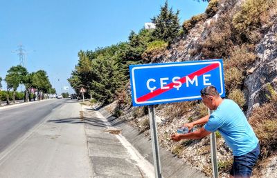 Low angle view of road sign against blue sky