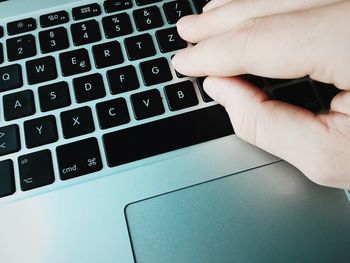 Cropped image of hand typing on laptop