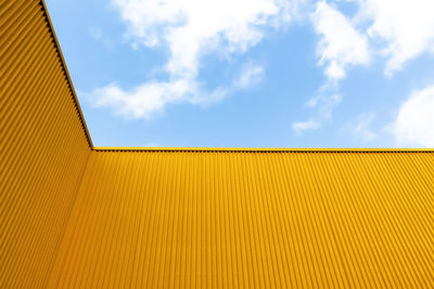 Low angle view of yellow building against sky