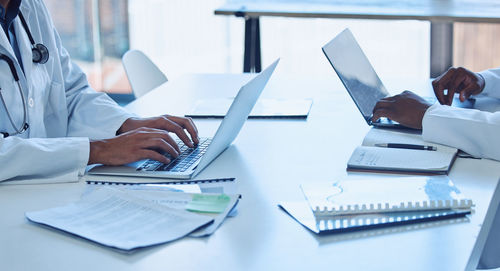 Midsection of businessman working on table