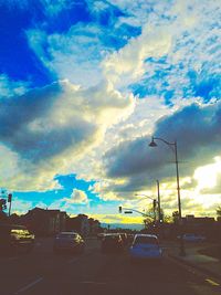 Cars on road against cloudy sky